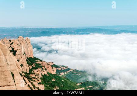 Vue depuis le pic Sant Jeroni des montagnes de Montserrat et des nuages sur le paysage verdoyant Banque D'Images