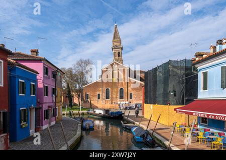 Burano, lagune vénitienne, Italie - 23 mars 2024 - vue sur le canal jusqu'à l'église Saint Martin évêque (Chiesa Parrocchiale di San Martino Vescovo). Banque D'Images