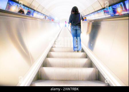 Londres, Royaume-Uni. Jeune femme sur l'escalatore dans la station de métro de Bond Street sur la ligne Elizabeth Banque D'Images