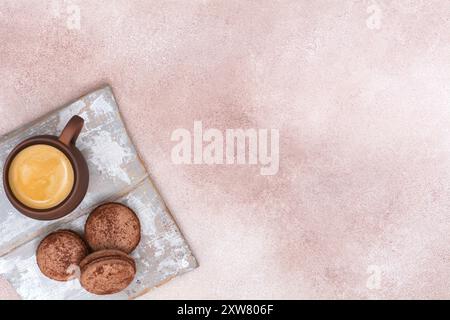 Tasse de café et macarons au chocolat sur planche de bois. Vue de dessus Banque D'Images