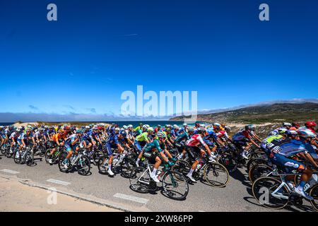 Cascais, Portugal. 18 août 2024. Une vue générale du peloton passant par la plage de Guincho lors de la 79ème la Vuelta Ciclista a Espana 2024, étape 2. Crédit : SOPA images Limited/Alamy Live News Banque D'Images