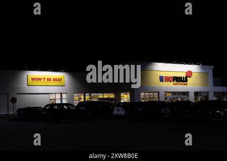 Vue nocturne d'un supermarché lumineux No Frills avec texte lumineux WNE BE BEAT. Prise à Toronto, Canada. Banque D'Images