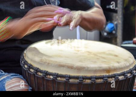 Gros plan de mains floues en mouvement jouant du djembé ou du tambour de jembé lors d'un festival de musique Banque D'Images