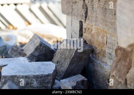 Pierres de carrière ensoleillées empilées sur un fond flou, présentant diverses nuances de gris et de brun avec des bords tranchants et des textures rugueuses. Prise à Tor Banque D'Images