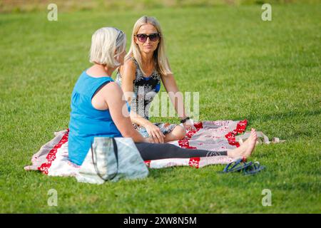 Les Burys, Godalming. 18 août 2024. Un après-midi chaud et ensoleillé pour les Home Counties. Les gens apprécient la musique dans le parc au Godalming Bandstand dans le Surrey. Tous les dimanches après-midi pendant les mois d'été, de la musique live est jouée avec une variété de genres couverts. Cet après-midi, c'était le tour de 'The Band of the Surrey Yeomanry', parrainé par BL Vision de Farncombe. Crédit : james jagger/Alamy Live News Banque D'Images