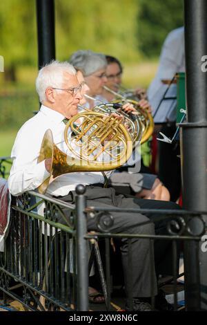 Les Burys, Godalming. 18 août 2024. Un après-midi chaud et ensoleillé pour les Home Counties. Les gens apprécient la musique dans le parc au Godalming Bandstand dans le Surrey. Tous les dimanches après-midi pendant les mois d'été, de la musique live est jouée avec une variété de genres couverts. Cet après-midi, c'était le tour de 'The Band of the Surrey Yeomanry', parrainé par BL Vision de Farncombe. Crédit : james jagger/Alamy Live News Banque D'Images