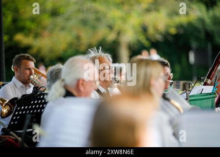 Les Burys, Godalming. 18 août 2024. Un après-midi chaud et ensoleillé pour les Home Counties. Les gens apprécient la musique dans le parc au Godalming Bandstand dans le Surrey. Tous les dimanches après-midi pendant les mois d'été, de la musique live est jouée avec une variété de genres couverts. Cet après-midi, c'était le tour de 'The Band of the Surrey Yeomanry', parrainé par BL Vision de Farncombe. Crédit : james jagger/Alamy Live News Banque D'Images