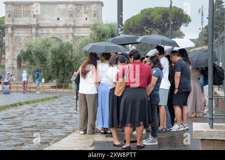 Rome, Italie. 18 août 2024. Les touristes qui font la queue pour entrer dans le Parc archéologique du Colisée se protègent de la pluie suite à un changement radical de la situation météorologique à Rome. Isolés des précipitations dispersées avec des averses ou des orages sont les prévisions météorologiques pour Rome et le Latium et le département de la protection civile du Capitole a émis l'alerte jaune émise par la Direction régionale des urgences. En plus de la pluie, le Latium devrait connaître ''˜de fortes averses, une activité électrique fréquente, des tempêtes de grêle locales et de fortes rafales de windâ (crédit image : © Marcello Valeri/ZUMA Press Banque D'Images