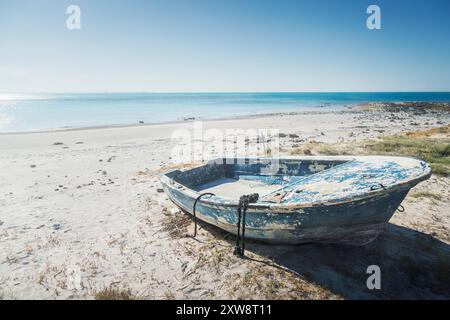 Paysage marin avec un vieux bateau bleu abandonné sur une plage blanche à Vada. Région Toscane, Italie Banque D'Images