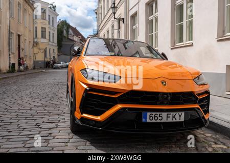 Tallinn, Estonie - 19 juillet 2023 : une Lamborghini Urus orange frappante garée dans le centre-ville de Tallinn, reflétant l'élégance et l'exclusivité de ce VUS de luxe haute performance *** Ein auffälliger orangefarbener Lamborghini Urus parkt in der Innenstadt von Tallinn und spiegelt die Eleganz und Exklusivität dieses leistungsstarken Luxus-SUV Wider Banque D'Images