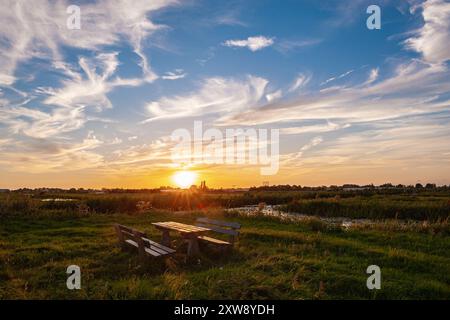 Beau ciel de coucher de soleil sur une aire de repos de randonnée dans le paysage de polder néerlandais près de Gouda, aux pays-Bas. Banque D'Images