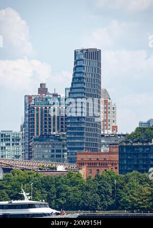 Les appartements en copropriété Olympia DUMBO en forme de voile géante se dressent derrière le point de repère Eagle Warehouse & Storage dans cette vue depuis un ferry East River. Banque D'Images