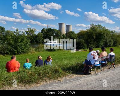 Les gens sur la rivière main regardant la rivière main avec un bateau de police et attendant une démolition des tours de refroidissement de la centrale nucléaire de Grafenrheinfeld. Grafenrheinfeld, Bavière, Allemagne - 16.08.2024 Banque D'Images