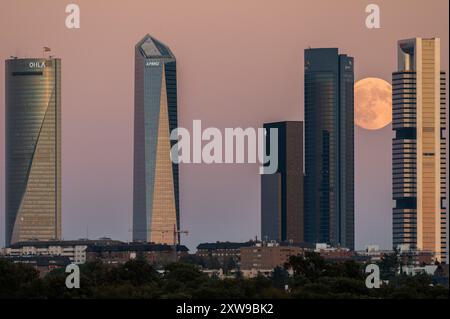 Madrid, Espagne. 18 août 2024. La presque pleine lune d'août connue sous le nom de lune de l'esturgeon se levant sur les gratte-ciel de la ligne d'horizon de Madrid connu sous le nom de la zone d'affaires des quatre tours. Crédit : Marcos del Mazo/Alamy Live News Banque D'Images