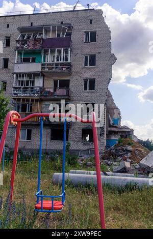 Ruines d'un immeuble d'appartements à Izium, dans l'immeuble bombardé par les Russes, plusieurs dizaines de familles sont mortes. Un immeuble divisé en deux par des missiles russes, avec une aire de jeux pour enfants au premier plan. Izium Ukraine Copyright : xMikolajxJaneczekx Banque D'Images