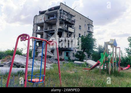 Ruines d'un immeuble d'appartements à Izium, dans l'immeuble bombardé par les Russes, plusieurs dizaines de familles sont mortes. Un immeuble divisé en deux par des missiles russes, avec une aire de jeux pour enfants au premier plan. Izium Ukraine Copyright : xMikolajxJaneczekx Banque D'Images