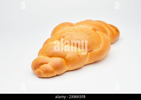 Pain tressé doré doux avec des graines de sésame sur fond blanc, parfait pour les photos de stock alimentaire Banque D'Images