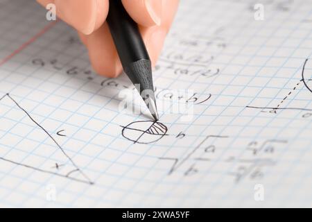 Femmes écriture main formules mathématiques dans copybook, gros plan Banque D'Images