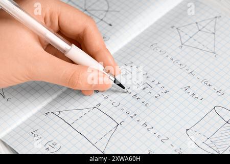 Femmes écriture main formules mathématiques dans copybook, gros plan Banque D'Images