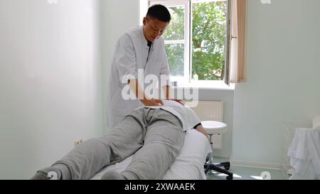 Berlin, Allemagne. 11 juillet 2024. Un médecin en médecine traditionnelle chinoise de l'Université de médecine chinoise de Pékin Koetzting Hospital aide un patient avec un massage réparateur dans la ville de Bad Koetzting dans le sud-est de l'Allemagne, le 11 juillet 2024. POUR ALLER AVEC 'Feature : les traitements TCM gagnent en reconnaissance en Allemagne pour l'efficacité, moins d'effets secondaires' crédit : Jia Jinming/Xinhua/Alamy Live News Banque D'Images