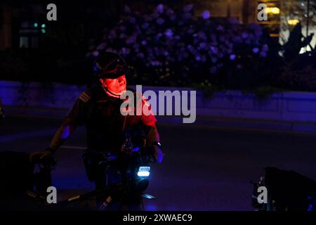 Chicago, États-Unis. 18 août 2024. CHICAGO, ILLINOIS - 18 AOÛT : la police regarde les manifestants pro-palestiniens marcher avant la Convention nationale démocrate le 18 août 2024 à Chicago, Illinois. La convention se déroule du 19 au 22 août. Crédit : Jeremy Hogan/Alamy Live News Banque D'Images