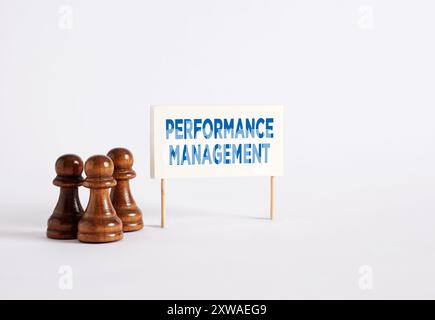 Gestion des performances, amélioration ou développement en entreprise. Pions d'échecs debout à côté d'une bannière avec le mot gestion de la performance. Banque D'Images