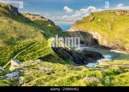 15 mai 2023 : Tintagel, Cornouailles - Château de Tintagel, lieu de naissance légendaire du roi Arthur. Merlin's Cave peut être vu dans la falaise sous le château. Banque D'Images