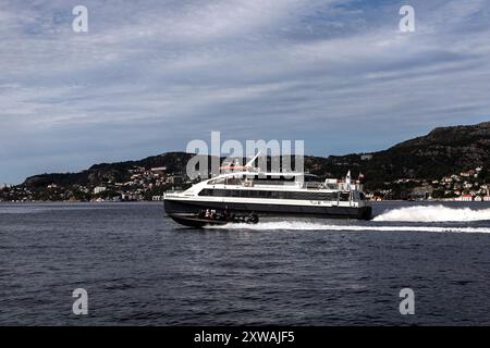 Catamaran de passagers à grande vitesse Admiralen à Byfjorden, au départ du port de Bergen, Norvège. Un petit bateau à grande vitesse passant à une vitesse plus élevée Banque D'Images