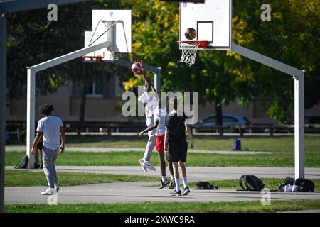 Bron, Venissieux, Parilly Park (centre-est de la France) : sports à l'aire de jeux. Groupe de jeunes jouant au basket-ball Banque D'Images