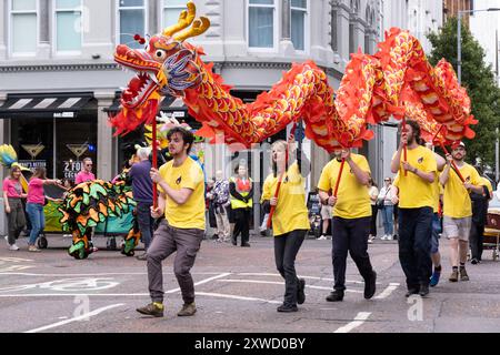 Équipe de dragons danseurs chinois participant à la célébration annuelle du Carnaval multiculturel de Belfast Mela dans le centre-ville. Belfast, Royaume-Uni - 17 août 2024. Banque D'Images