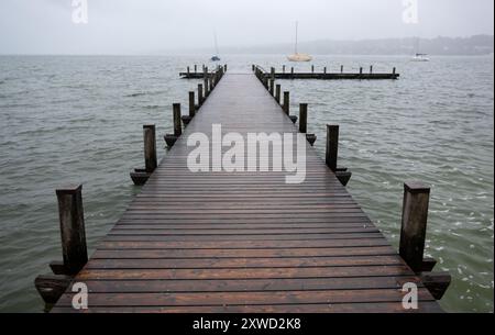 Percha, Allemagne. 19 août 2024. Des nuages sombres dérivent au-dessus d'une jetée sur le lac Starnberg. Crédit : Sven Hoppe/dpa/Alamy Live News Banque D'Images