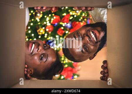 Heureux couple afro cadeau de Noël à la maison Banque D'Images