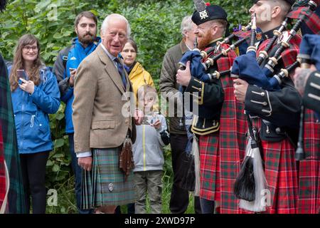 Le roi Charles III rencontre les membres de la bande du Royal Regiment of Scotland et les tuyaux et tambours du Royal corps of Signals après avoir inspecté la Balaklava Company, 5e bataillon, le Royal Regiment of Scotland, aux portes de Balmoral, comme il prend résidence d'été au château. Date de la photo : lundi 19 août 2024. Banque D'Images