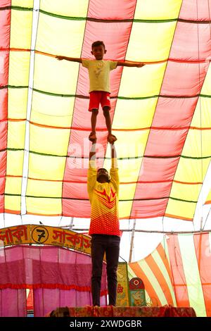 Sirajganj, Sirajganj, Bangladesh. 19 août 2024. Les membres de ''The New Lucky 7 Circus'' divertissent le public en exerçant leurs compétences sous une tente colorée à Sirajganj, au Bangladesh. Le cirque est une forme de divertissement populaire au Bangladesh qui est presque en train de disparaître. Une tradition de presque cent ans, ce jeu est montré dans une immense tente colorée. Ici, les artistes mettent en valeur leurs compétences à travers des cascades, acrobaties, clowns, marionnettes, marche serrée. (Crédit image : © Syed Mahabubul Kader/ZUMA Press Wire) USAGE ÉDITORIAL SEULEMENT! Non destiné à UN USAGE commercial ! Banque D'Images