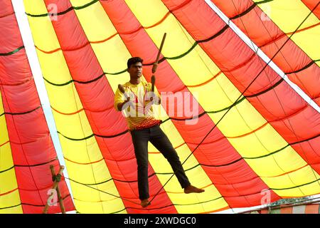 Sirajganj, Sirajganj, Bangladesh. 19 août 2024. Un membre de ''The New Lucky 7 Circus'' divertit le public en exécutant ses talents sous une tente colorée à Sirajganj, au Bangladesh. Le cirque est une forme de divertissement populaire au Bangladesh qui est presque en train de disparaître. Une tradition de presque cent ans, ce jeu est montré dans une immense tente colorée. Ici, les artistes mettent en valeur leurs compétences à travers des cascades, acrobaties, clowns, marionnettes, marche serrée. (Crédit image : © Syed Mahabubul Kader/ZUMA Press Wire) USAGE ÉDITORIAL SEULEMENT! Non destiné à UN USAGE commercial ! Banque D'Images