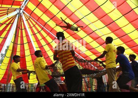 Sirajganj, Sirajganj, Bangladesh. 19 août 2024. Les membres de ''The New Lucky 7 Circus'' divertissent le public en exerçant leurs compétences sous une tente colorée à Sirajganj, au Bangladesh. Le cirque est une forme de divertissement populaire au Bangladesh qui est presque en train de disparaître. Une tradition de presque cent ans, ce jeu est montré dans une immense tente colorée. Ici, les artistes mettent en valeur leurs compétences à travers des cascades, acrobaties, clowns, marionnettes, marche serrée. (Crédit image : © Syed Mahabubul Kader/ZUMA Press Wire) USAGE ÉDITORIAL SEULEMENT! Non destiné à UN USAGE commercial ! Banque D'Images