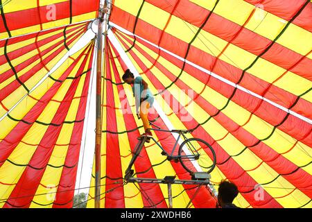 Sirajganj, Sirajganj, Bangladesh. 19 août 2024. Un membre de ''The New Lucky 7 Circus'' divertit le public en effectuant un numéro d'équilibre tout en se tenant debout sur un vélo à Sirajganj, au Bangladesh. Le cirque est une forme de divertissement populaire au Bangladesh qui est presque en train de disparaître. Une tradition de presque cent ans, ce jeu est montré dans une immense tente colorée. Ici, les artistes mettent en valeur leurs compétences à travers des cascades, acrobaties, clowns, marionnettes, marche serrée. (Crédit image : © Syed Mahabubul Kader/ZUMA Press Wire) USAGE ÉDITORIAL SEULEMENT! Non destiné à UN USAGE commercial ! Banque D'Images