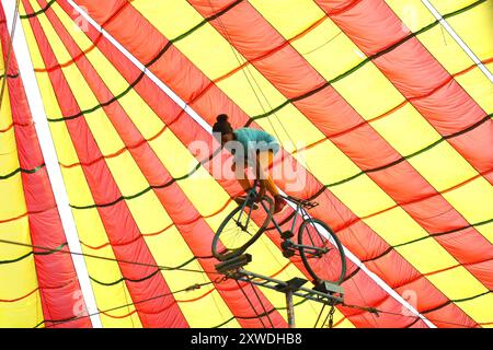 Sirajganj, Sirajganj, Bangladesh. 19 août 2024. Un membre de ''The New Lucky 7 Circus'' divertit le public en effectuant un numéro d'équilibre tout en se tenant debout sur un vélo à Sirajganj, au Bangladesh. Le cirque est une forme de divertissement populaire au Bangladesh qui est presque en train de disparaître. Une tradition de presque cent ans, ce jeu est montré dans une immense tente colorée. Ici, les artistes mettent en valeur leurs compétences à travers des cascades, acrobaties, clowns, marionnettes, marche serrée. (Crédit image : © Syed Mahabubul Kader/ZUMA Press Wire) USAGE ÉDITORIAL SEULEMENT! Non destiné à UN USAGE commercial ! Banque D'Images