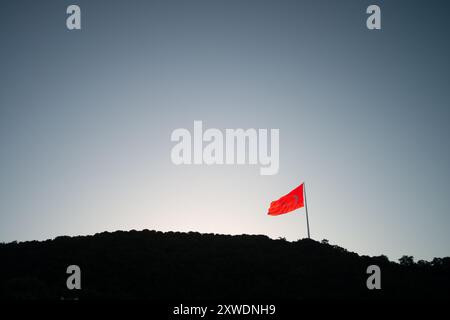 Une image puissante du drapeau turc agitant fièrement au sommet d'une montagne, symbolisant la force, la liberté et la fierté nationale, sur fond de vaste Banque D'Images