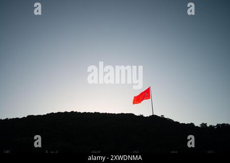 Une image puissante du drapeau turc agitant fièrement au sommet d'une montagne, symbolisant la force, la liberté et la fierté nationale, sur fond de vaste Banque D'Images