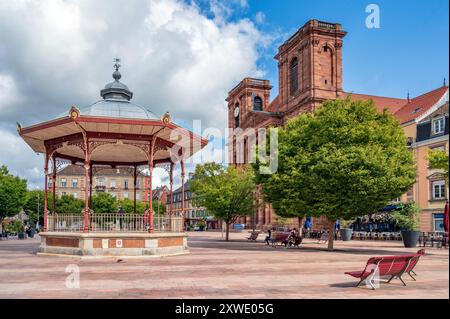 La place d'armes à Belfort, France, avec la cathédrale Saint-Christophe de Belfort et un pavillon de musique nostalgique. Banque D'Images