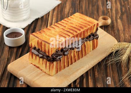 Roti Bakar Bandung, Roti Bakar Cokelat. Pain grillé avec confiture de chocolat. Sur la table en bois Banque D'Images