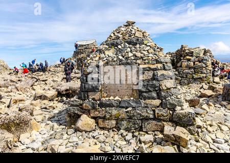 Cairn en pierre avec la plaque du mémorial de la paix Ben Nevis sur les ruines de l'observatoire de la fin du XIXe siècle au sommet de Ben Nevis, Highlands, Écosse Royaume-Uni Banque D'Images