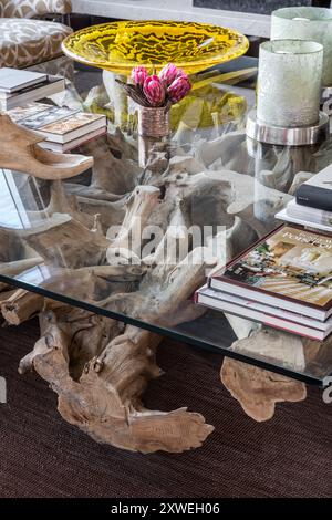 Base Driftwood soutenant la table en verre dans la maison britannique moderne de luxe. Londres, Royaume-Uni Banque D'Images