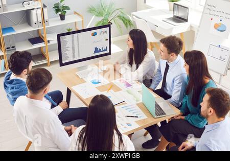 Équipe de professionnels d'affaires ayant réunion de travail, assis autour de la table et regardant l'ordinateur Banque D'Images