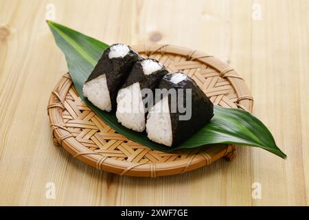 Onigiri maison (boulettes de riz), cuisine japonaise traditionnelle. La garniture est composée de flocons de saumon, d'umeboshi (prunes marinées) et de mentaiko (œufs de morue épicés). Banque D'Images