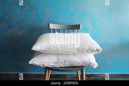 Sommeil sain, intérieur domestique, pile d'oreillers blancs pliés sur la chaise à la maison Banque D'Images