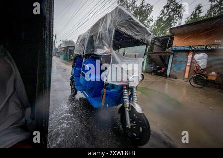 Autorickshaw sous une pluie battante. Banque D'Images