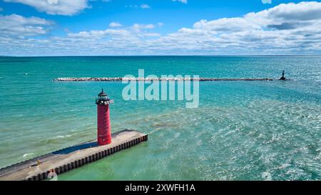 Vue aérienne du phare rouge sur la jetée avec des eaux turquoise Banque D'Images