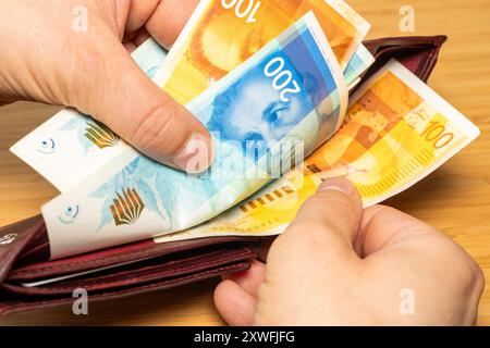 Israël argent. Main prenant l'argent du portefeuille. Shekels israéliens, concept financier Banque D'Images